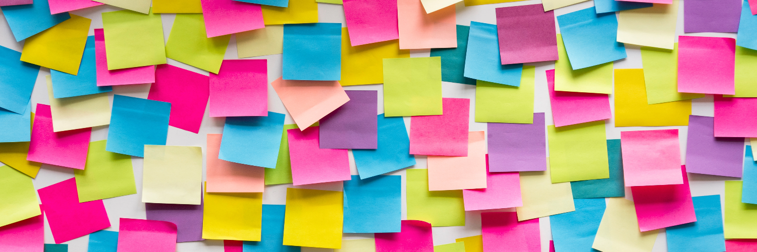 A wall covered in blank multi coloured post it notes 
