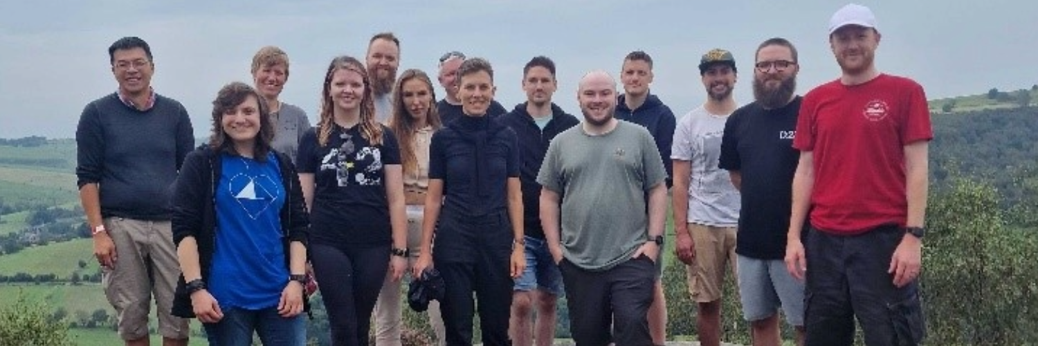 Codecabin attendees gathered in a group, standing on top of a hill 